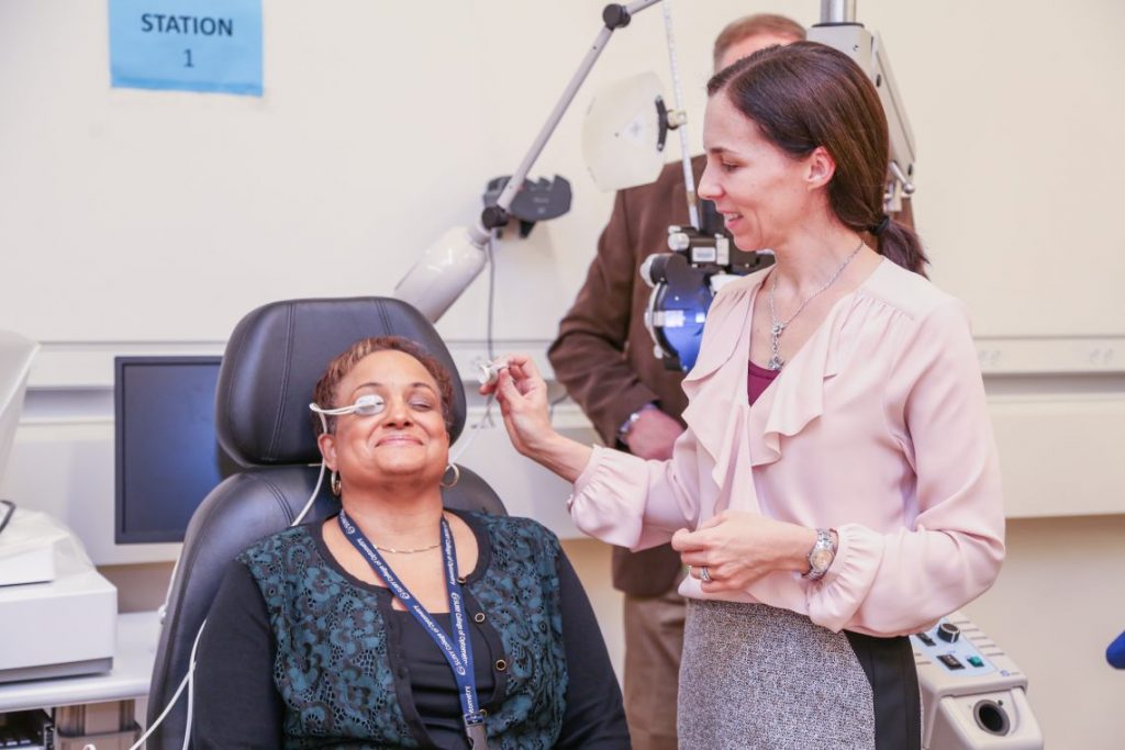 Doctor putting eye testing equipment on patients eyes