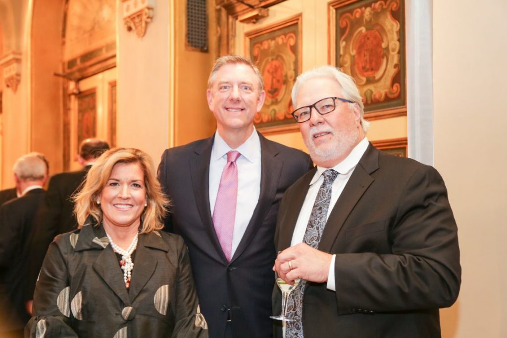 2 men and woman posing for photo at formal event