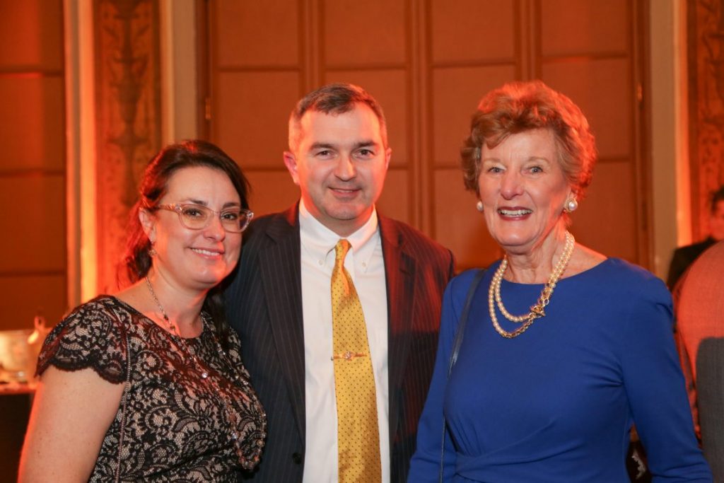 2 woman and man at formal event posing for photo
