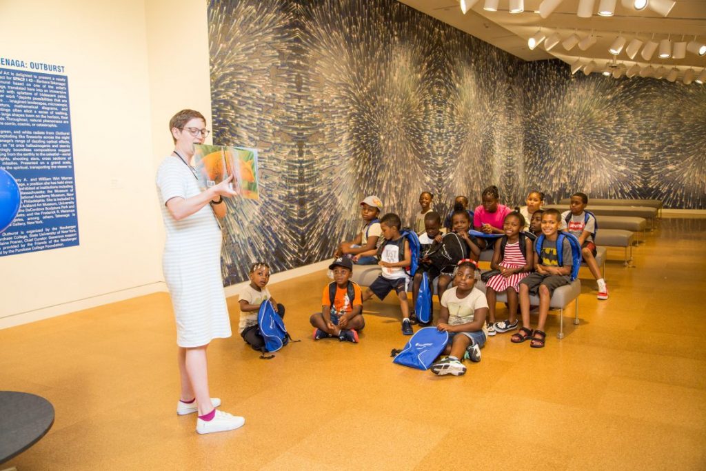Woman reading book to children