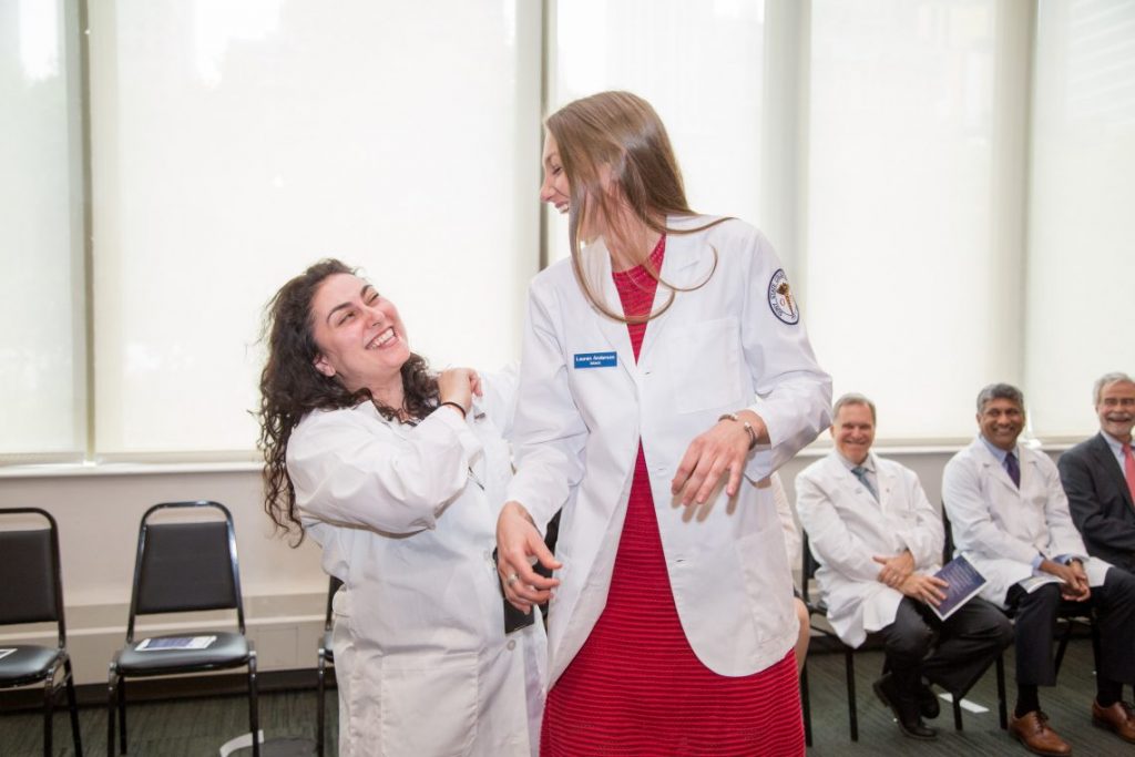 Students recieving white coats